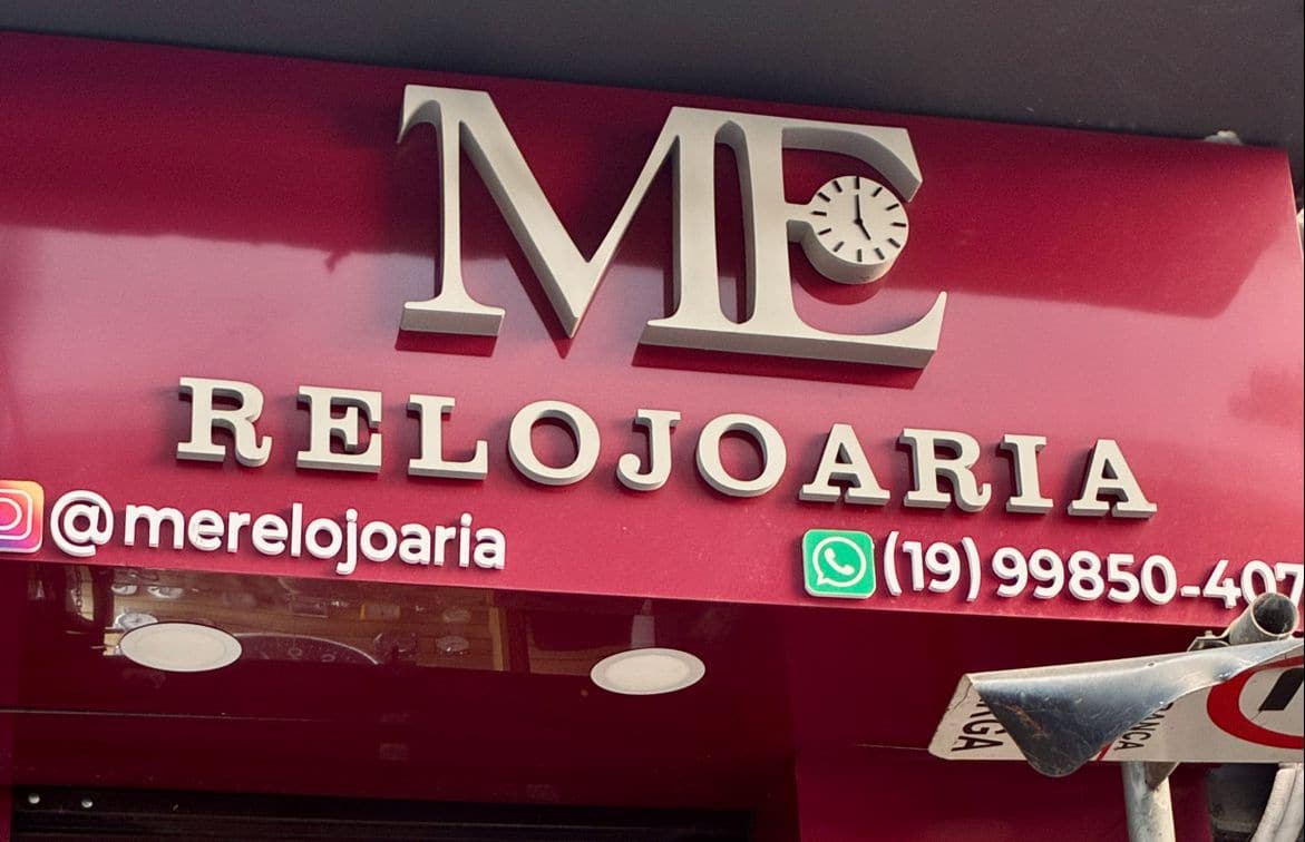 Letreiro vermelho da ME Relojoaria na fachada da loja no Centro de Campinas, com Instagram e WhatsApp