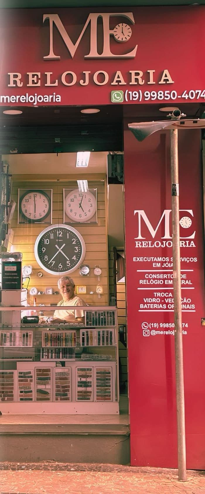Fachada vermelha da ME Relojoaria na Rua Ernesto Khulmann, com o letreiro e a vitrine de relógios